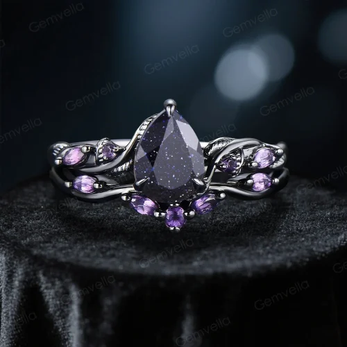 Nature-inspired engagement ring with pear-cut galaxy blue sandstone and amethyst, in black gold vine band.