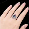 Woman wearing pear alexandrite engagement ring and Celtic knot wedding band, lifestyle photo