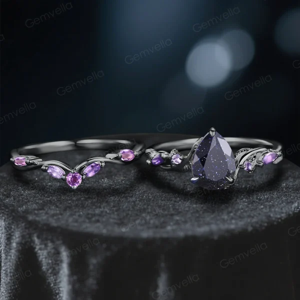 Close-up of pear-cut galaxy blue sandstone engagement ring with black gold vine setting
