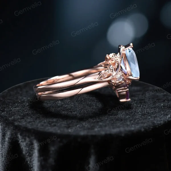 Side view of pear aquamarine ring and vine wedding band set with leaf designs