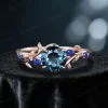 Front view of a vintage rose gold ring featuring a 1ct round natural London Blue Topaz paired with Blue Sapphire accents, showcasing the intricate nature-inspired setting and blue gemstone design.