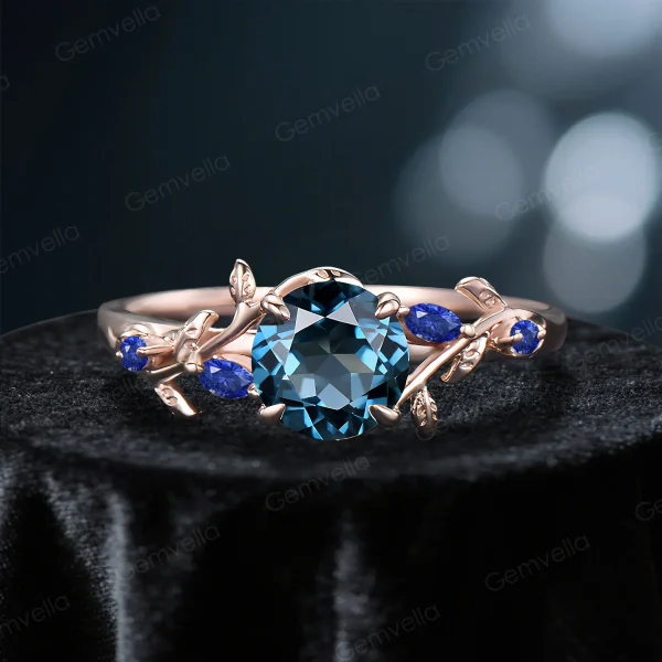 Front view of a vintage rose gold ring featuring a 1ct round natural London Blue Topaz paired with Blue Sapphire accents, showcasing the intricate nature-inspired setting and blue gemstone design.