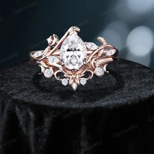 Front view of handcrafted 14K rose gold pear cut moissanite ring set featuring unique stars moon and twisted leaf vine design, nature inspired bridal engagement ring with detailed celestial accents