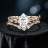 Close-up front view of a 1.25 carat pear cut moissanite bridal ring set featuring a nature-inspired rose gold band with detailed twig and leaf accents surrounding the center stone.