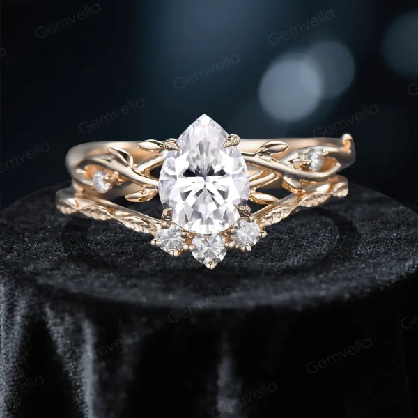 Close-up front view of a 1.25 carat pear cut moissanite bridal ring set featuring a nature-inspired rose gold band with detailed twig and leaf accents surrounding the center stone.