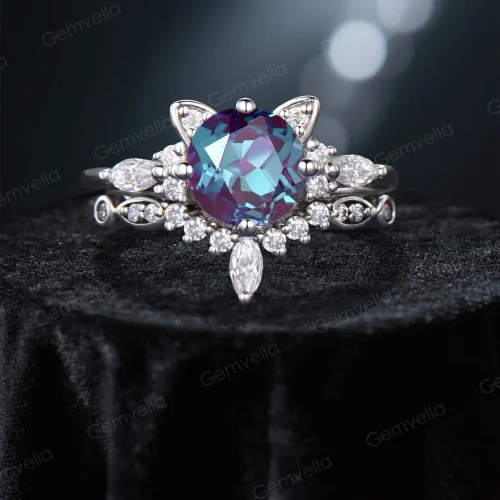 Front view of a unique cat themed engagement ring featuring a round cut color-change alexandrite center stone and moissanite accents in white gold, showcasing the detailed kitten design.