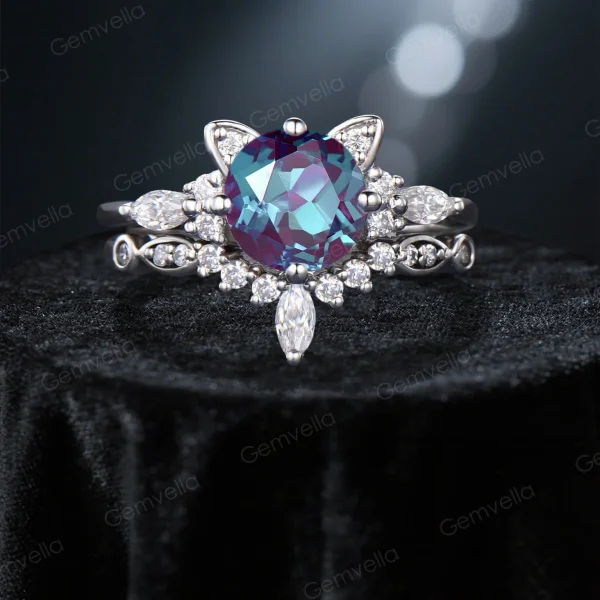 Front view of a unique cat themed engagement ring featuring a round cut color-change alexandrite center stone and moissanite accents in white gold, showcasing the detailed kitten design.