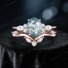 Front view of 1.5ct oval natural green moss agate and marquise moissanite cluster engagement ring set in 10k rose gold