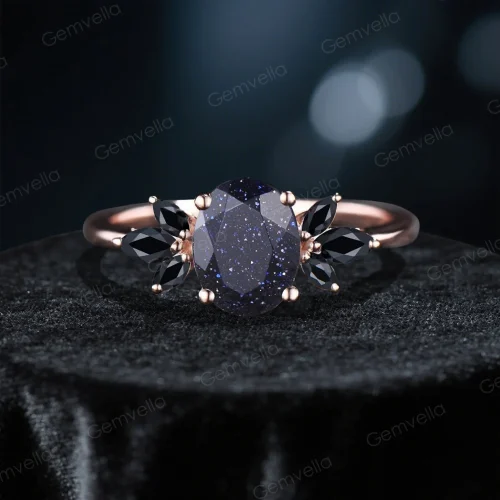 front view of 1.5 carat oval cut blue sandstone engagement ring with galaxy starry sky cluster design and black gemstone accents