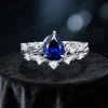 Front view of a 1.25 carat pear-shaped blue sapphire engagement ring featuring a nature-inspired sterling silver band with twig, vine, and leaf details.