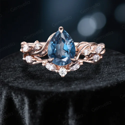 Front view of a 1.25ct pear cut London Blue Topaz engagement ring set featuring a nature inspired leaf and vine twist band design.