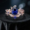Front view of a handmade 1.25ct pear cut blue sapphire engagement ring featuring a nature inspired leaf and branch design setting