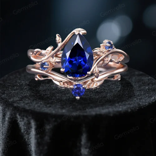 Front view of a handmade 1.25ct pear cut blue sapphire engagement ring featuring a nature inspired leaf and branch design setting