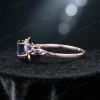Side profile of the blue sapphire ring, showcasing the intricate leaf and vine design carved into the rose gold band and the height of the gemstone setting.
