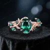 Front view of the main 1.5ct oval cut emerald engagement ring in 10K rose gold, highlighting the nature inspired leaf vine branch setting and vintage design