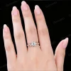 Close up of a vintage round cut moissanite engagement ring worn on a woman's finger, showcasing how the 14k gold floral leaf vine branch design looks when worn and the ring's scale on the hand.