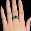 A realistic image of the vintage pear cut emerald engagement ring set being worn, demonstrating its appearance on a finger and serving as a promise ring or bridal jewelry gift.