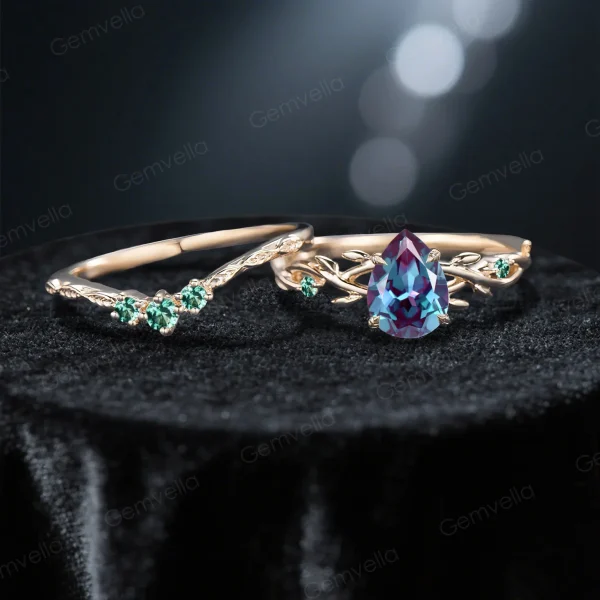 Flat lay photography of the nature inspired alexandrite engagement ring and wedding band set separated to show the intricate emerald leaf details and the pear shaped center stone.