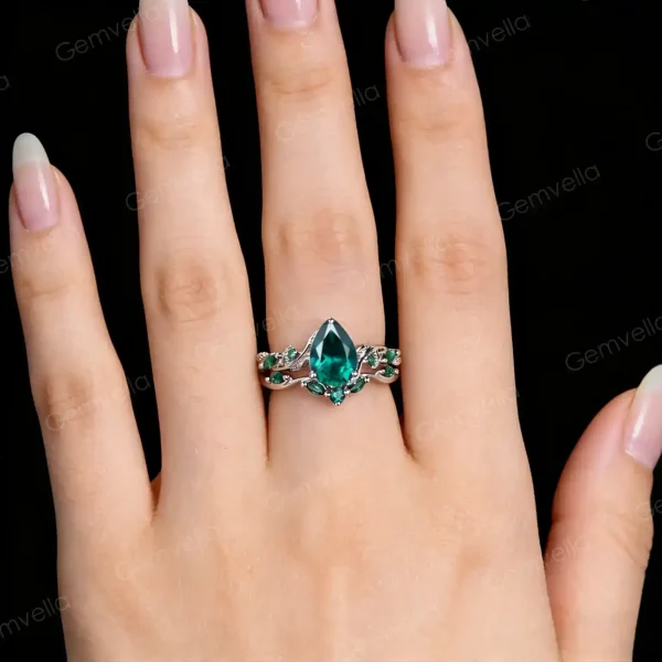 A realistic image of the vintage pear cut emerald engagement ring set being worn, demonstrating its appearance on a finger and serving as a promise ring or bridal jewelry gift.