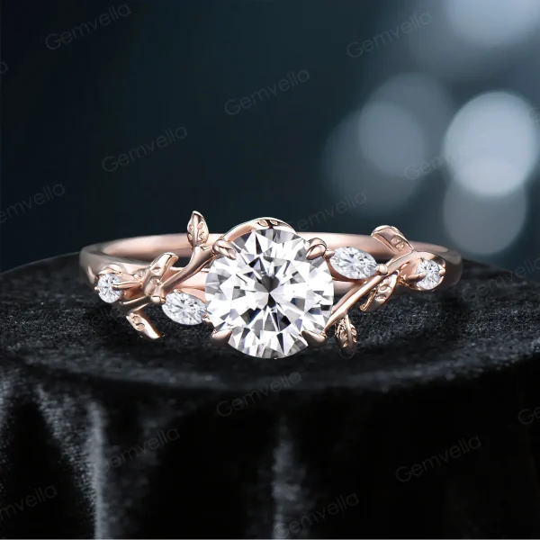 Front view of a vintage rose gold moissanite engagement ring featuring a round cut center stone surrounded by delicate leaf vine nature inspired setting, showcasing the diamond alternative gemstone and intricate bridal ring design