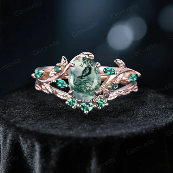Front view of a 1.5 carat oval moss agate and emerald ring set in 10k rose gold with vintage leaf and vine details.