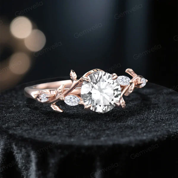 Angled view of a vintage rose gold moissanite engagement ring displaying the round cut diamond alternative gemstone, leaf vine nature inspired setting and elegant bridal ring design from a side angle