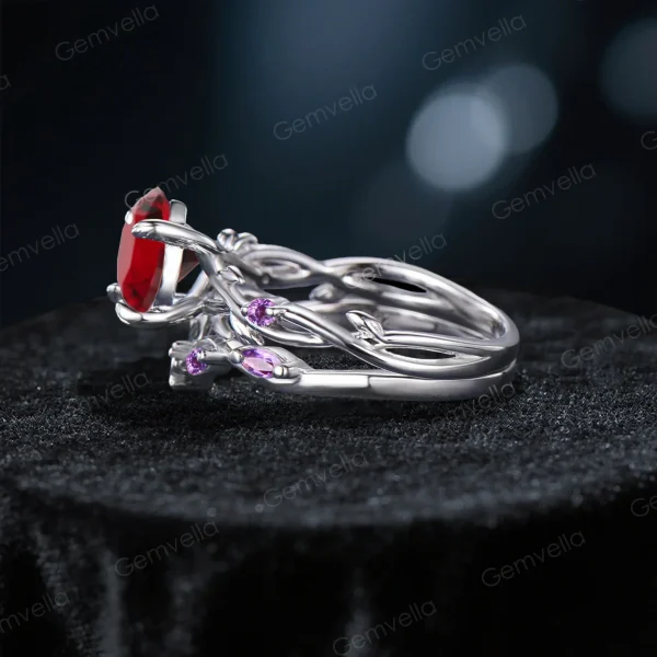 Side profile showcasing the substantial width of the sterling silver band, the raised cathedral setting of the Red Garnet, and the detailed leaf texture wrapping around the side of the ring shank with embedded Amethyst stones.
