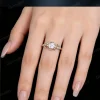 A woman's hand modeling the 1ct round cut moissanite engagement ring, demonstrating the fit and scale of the vintage celestial and nature inspired design in natural lighting.