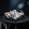 Front view of the main 1.5 carat oval moss agate engagement ring, featuring 10k rose gold vintage leaf vine branch design and emerald accents.