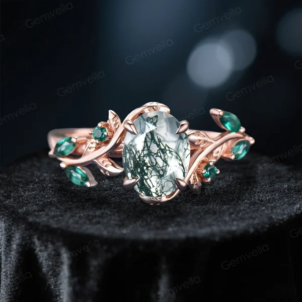 Front view of the main 1.5 carat oval moss agate engagement ring, featuring 10k rose gold vintage leaf vine branch design and emerald accents.