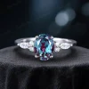Front view of a handcrafted vintage bridal set showcasing a 1.5ct oval color-change alexandrite center stone with a halo of marquise cut moissanite accents on a detailed band.