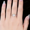 Close up of a woman's hand wearing a vintage rose gold moissanite engagement ring, showcasing the round cut diamond alternative gemstone, leaf vine nature inspired setting and elegant bridal ring fit on finger in real life