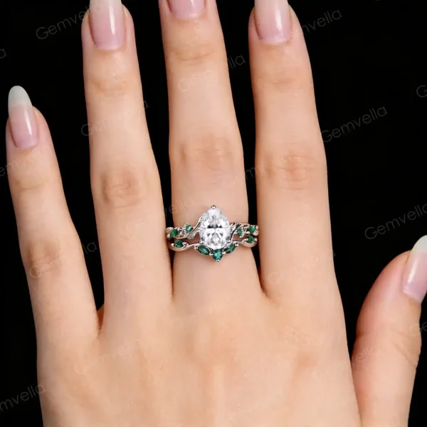 Woman's hand wearing the vintage nature inspired twig vine moissanite engagement ring set, showing how the pear cut and emerald cut promise rings look when worn together.