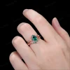 Lifestyle shot of a woman's hand wearing the 1.25ct pear shaped emerald wedding set, showcasing how the nature inspired yellow gold twig ring looks when worn and stacked on the finger.