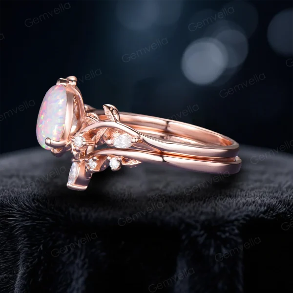 Side profile view of the 1.25ct pear cut white opal bridal set in 14k rose gold, highlighting the elegant bypass setting and the intricate leaf vine detail along the band shank.