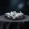 A delicate 925 sterling silver ring featuring a 1ct round moss agate stone. The design highlights a vintage moon and star theme with leaf green emerald accents, ideal for everyday wear or engagement.