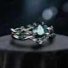 Angled perspective of the black gold engagement ring set with 1.25ct pear emerald and moss agate, displaying the gothic twig vine design from a three-quarter angle.
