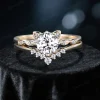 Front-facing image of a cat-themed engagement ring set, showcasing a round-cut moissanite center stone surrounded by cat ear-shaped prongs and diamond-like side stones, crafted in 14K yellow gold.