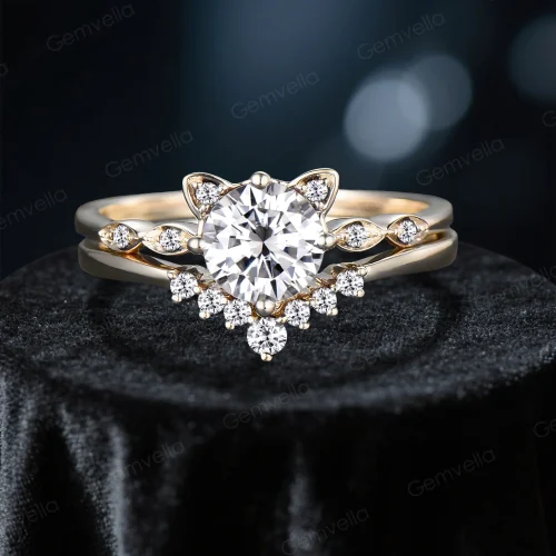 Front-facing image of a cat-themed engagement ring set, showcasing a round-cut moissanite center stone surrounded by cat ear-shaped prongs and diamond-like side stones, crafted in 14K yellow gold.