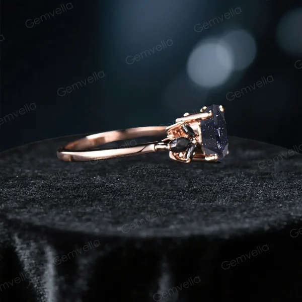 side profile of unique handmade proposal ring showing the 1.5ct blue sandstone setting height and black band thickness