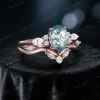 Side profile showing the height and detailed cluster setting of the oval moss agate and moissanite wedding set.