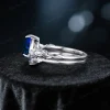 Side profile showing the delicate sterling silver twig and leaf motif wrapping around the band of the 1.25ct pear cut blue sapphire ring.