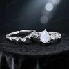Flat lay of 1.25ct pear cut opal engagement ring set displaying the full sterling silver nature inspired twig vine and leaf design, including both the engagement ring and matching band laid out on a neutral background