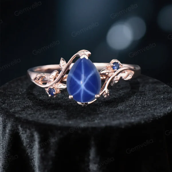 Close-up front view of the main engagement ring featuring the 1.25ct natural star sapphire with a distinct star effect and pear cut.