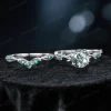 Flat lay photography of the two-piece ring set separated to show the detailed craftsmanship of the matching bands, highlighting the organic leaf patterns on both the engagement ring and the accompanying wedding band set with Emeralds.