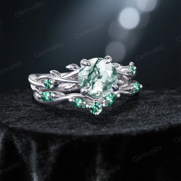 45-degree angle shot revealing the three-dimensional depth of the leaf and vine motif, the mossy landscape patterns within the central Agate, and the rich green sparkle of the surrounding Emerald accents.