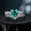 Front view of a vintage-inspired 1.2ct round cut green emerald ring featuring a twisting vine leaf design on the band.