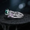 Side profile showing the intricate twisting vine leaf band and the gallery height of the 1.2ct round green emerald engagement ring.