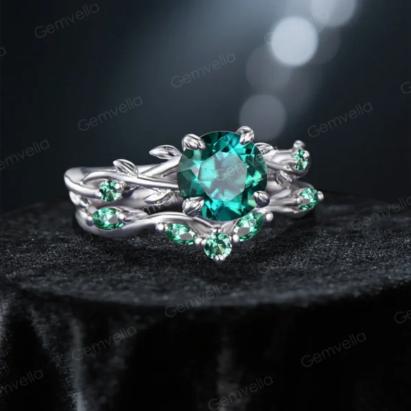 Angled view highlighting the sparkle of the round cut emerald and the organic texture of the handcrafted vine leaf design.