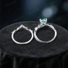 Top-down close-up showing the band thickness and the 1.2ct round cut green emerald table within the nature-inspired vine setting.
